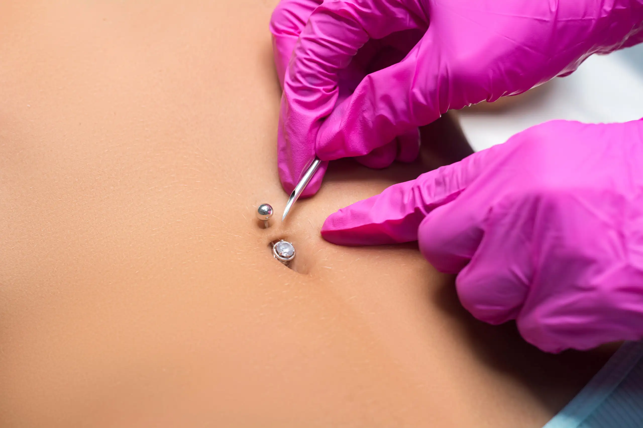 Pierçeuse portant des gants pendant un piercing